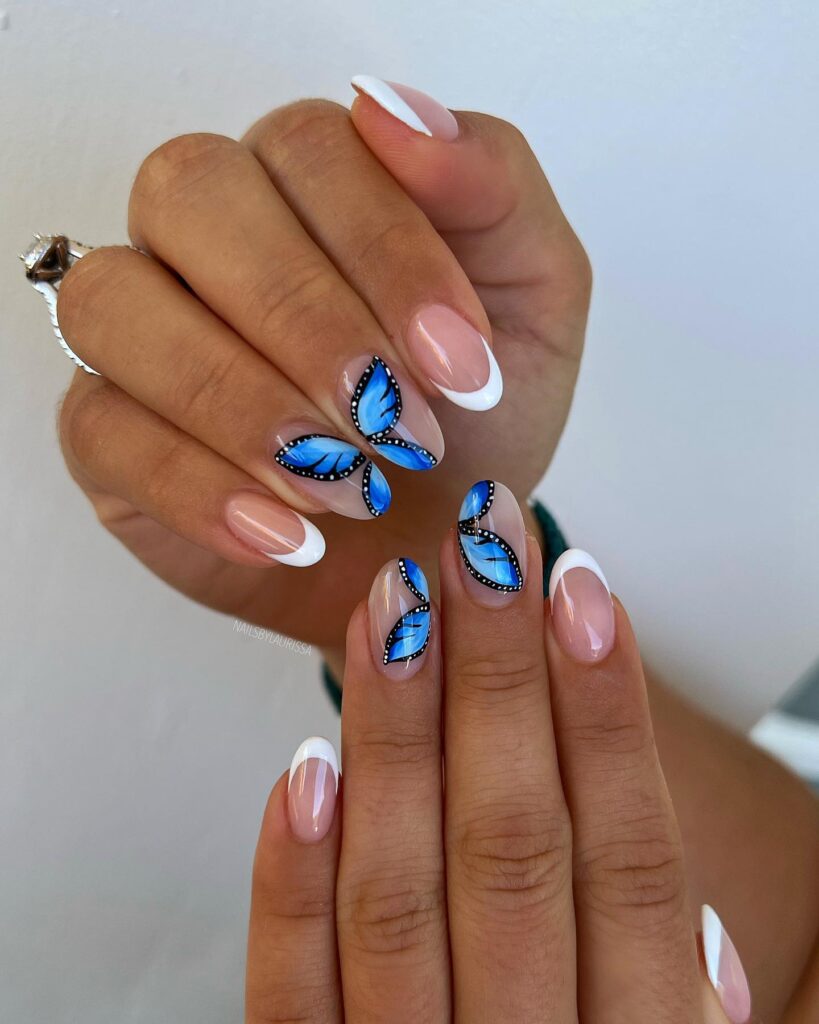 A stunning display of butterfly nails featuring pink, blue, and purple designs on acrylic and coffin nails.