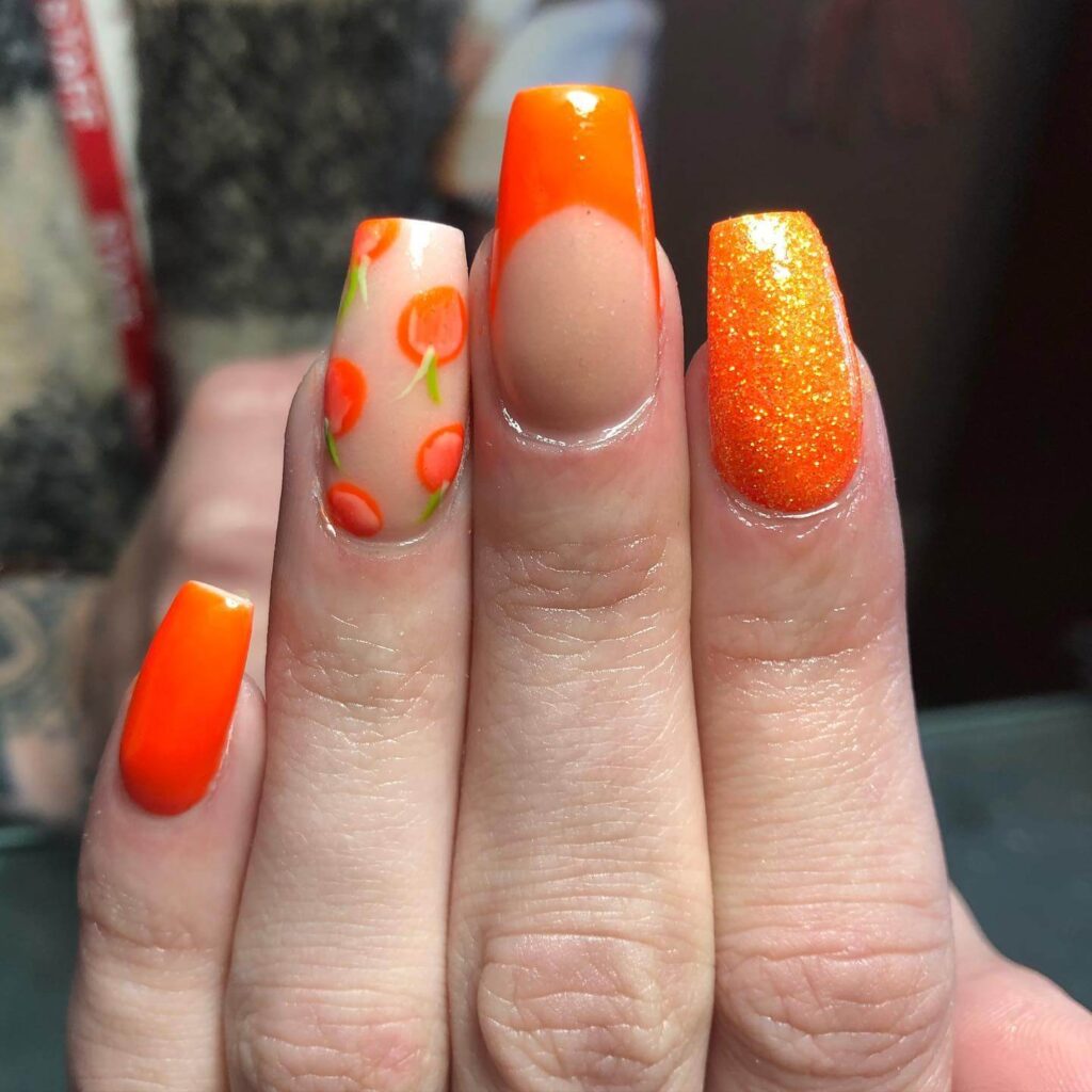 trendy summer nails with a range of orange shades including neon, burnt, and glitter finishes, ideal for seasonal flair.