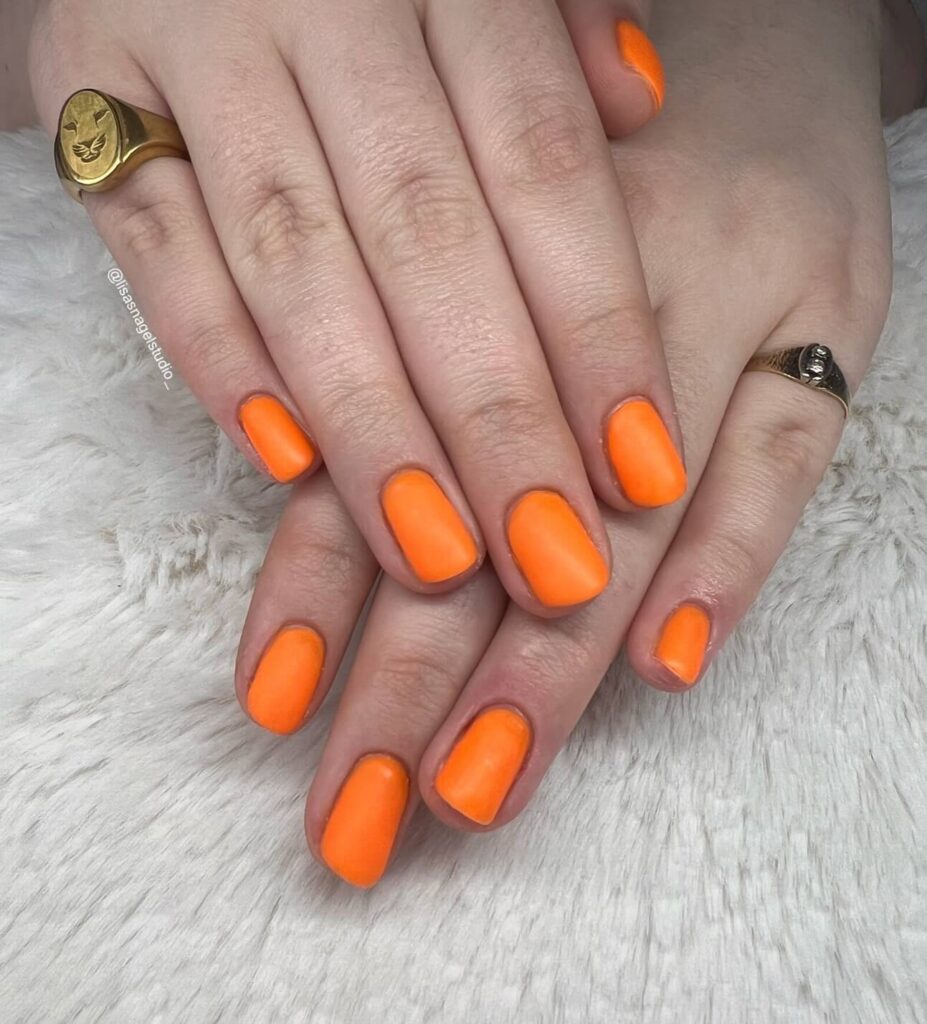 trendy summer nails with a range of orange shades including neon, burnt, and glitter finishes, ideal for seasonal flair.