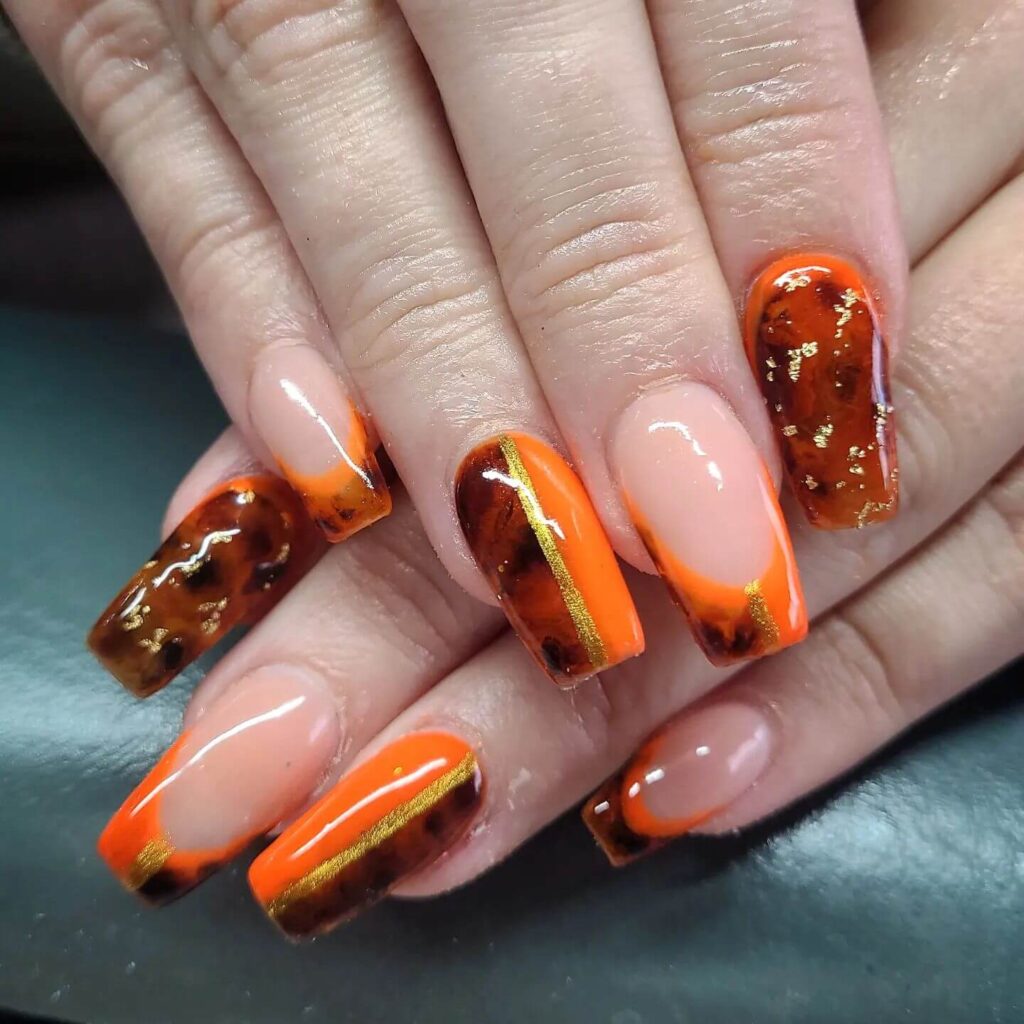 trendy summer nails with a range of orange shades including neon, burnt, and glitter finishes, ideal for seasonal flair.