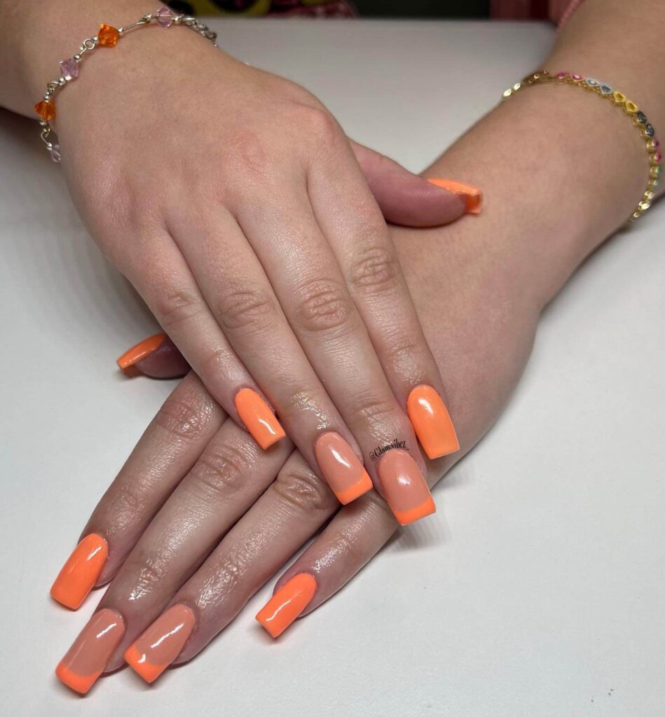 trendy summer nails with a range of orange shades including neon, burnt, and glitter finishes, ideal for seasonal flair.