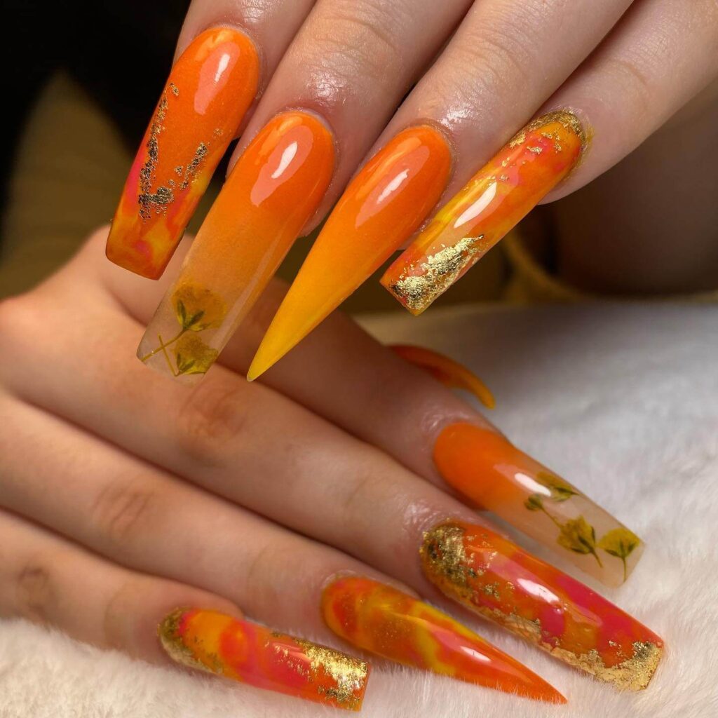 trendy summer nails with a range of orange shades including neon, burnt, and glitter finishes, ideal for seasonal flair.