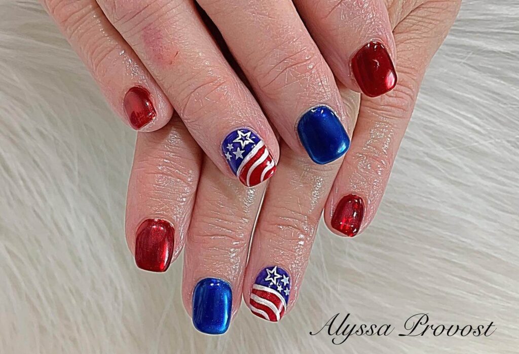 Colorful 4th of July nails featuring stars, stripes, and glitter in red, white, and blue.