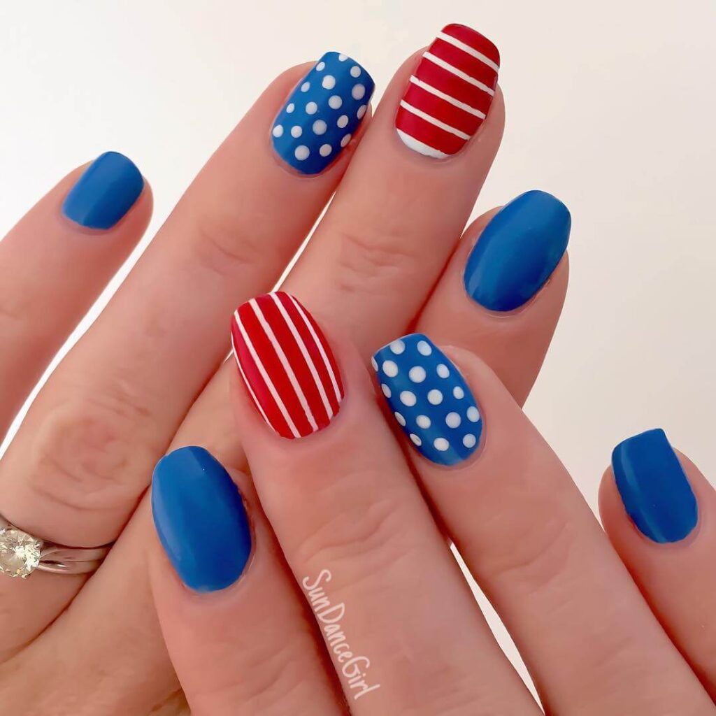 Colorful 4th of July nails featuring stars, stripes, and glitter in red, white, and blue.