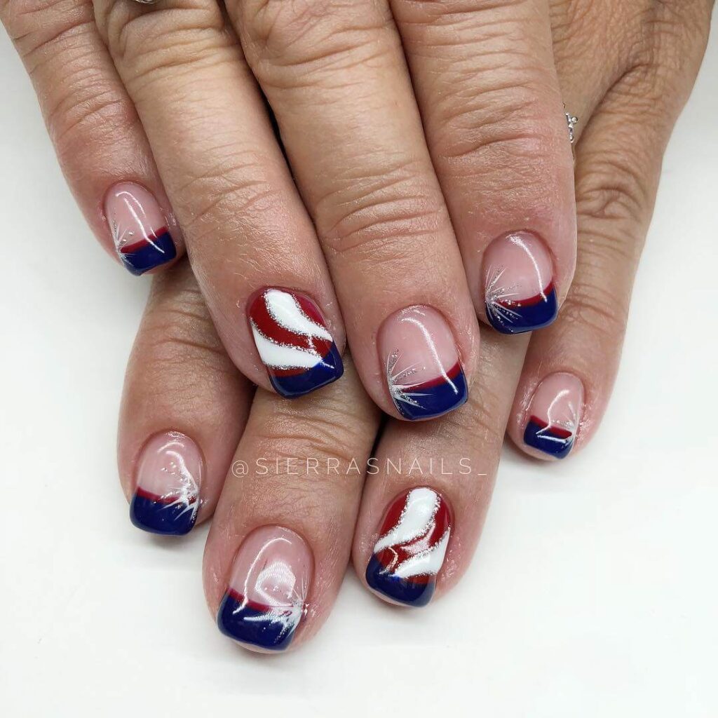 Colorful 4th of July nails featuring stars, stripes, and glitter in red, white, and blue.