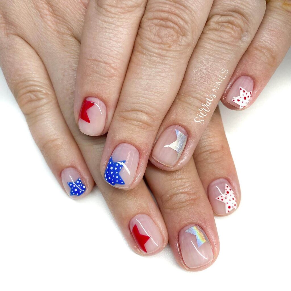 Colorful 4th of July nails featuring stars, stripes, and glitter in red, white, and blue.