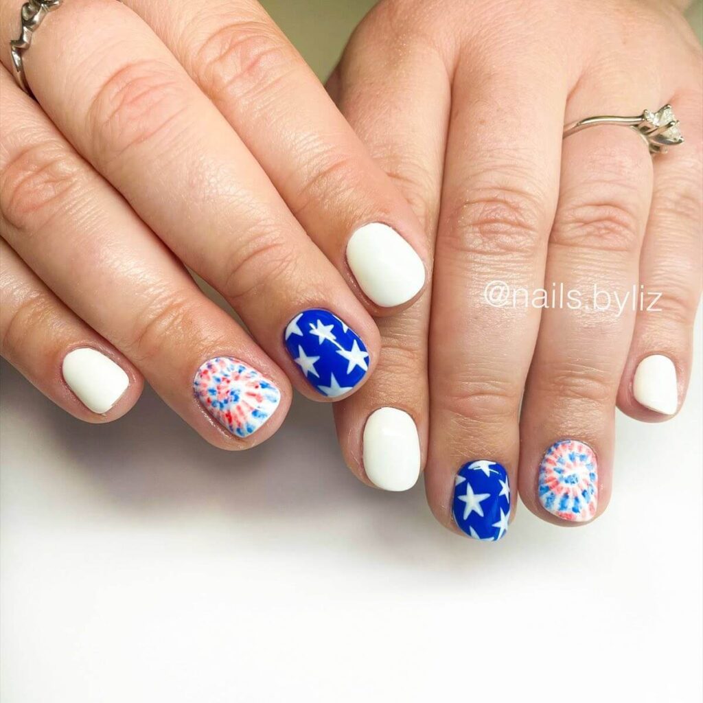 Colorful 4th of July nails featuring stars, stripes, and glitter in red, white, and blue.