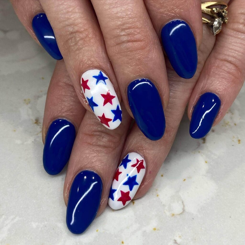 Colorful 4th of July nails featuring stars, stripes, and glitter in red, white, and blue.