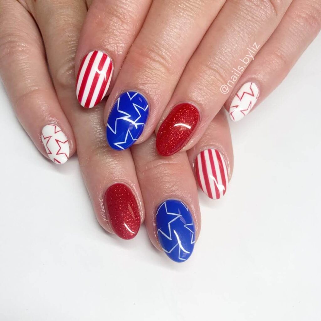 Colorful 4th of July nails featuring stars, stripes, and glitter in red, white, and blue.