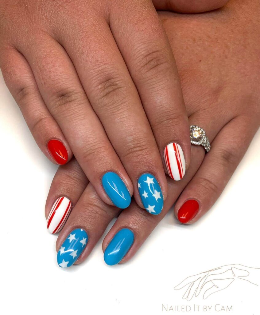 Colorful 4th of July nails featuring stars, stripes, and glitter in red, white, and blue.