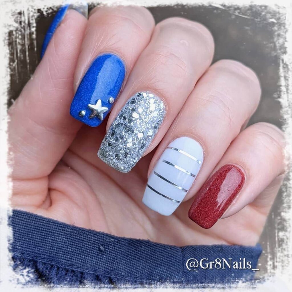 Colorful 4th of July nails featuring stars, stripes, and glitter in red, white, and blue.