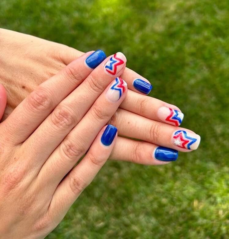 Colorful 4th of July nails featuring stars, stripes, and glitter in red, white, and blue.