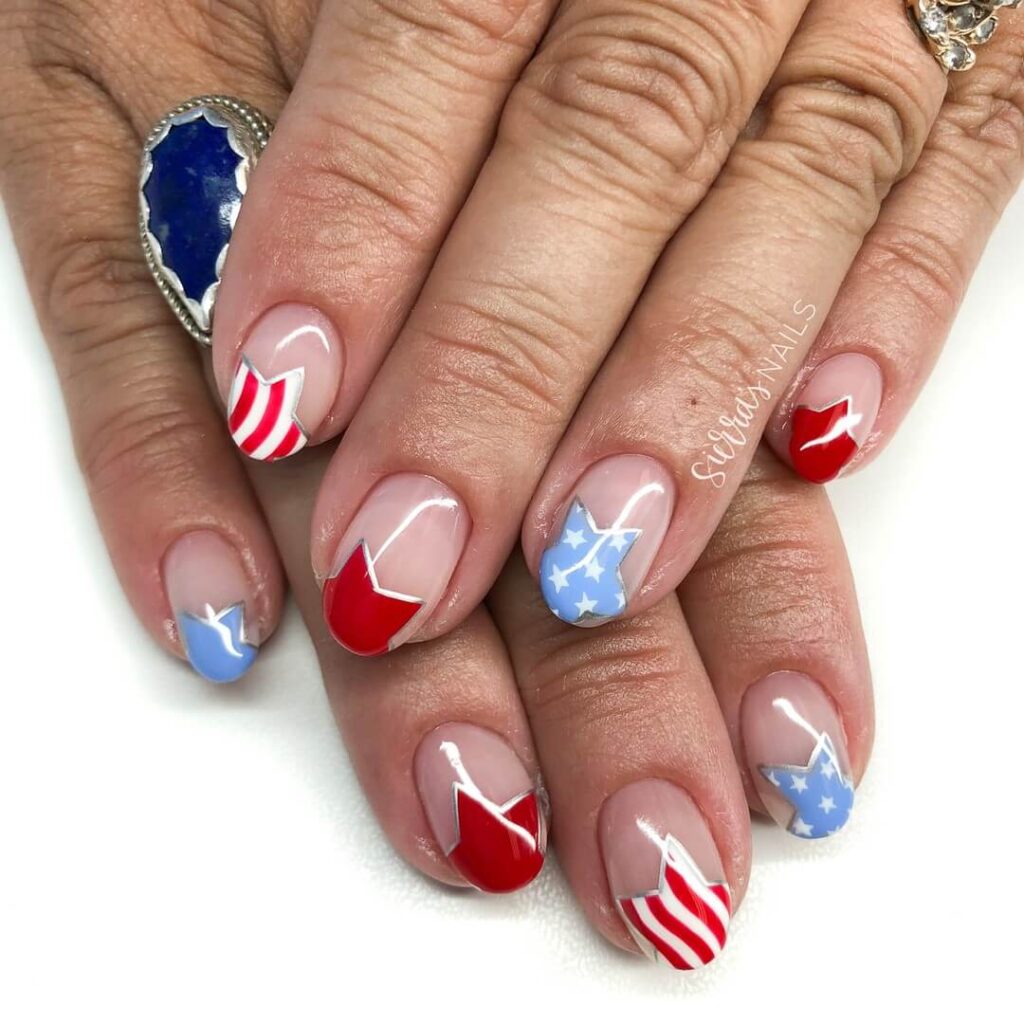 Colorful 4th of July nails featuring stars, stripes, and glitter in red, white, and blue.