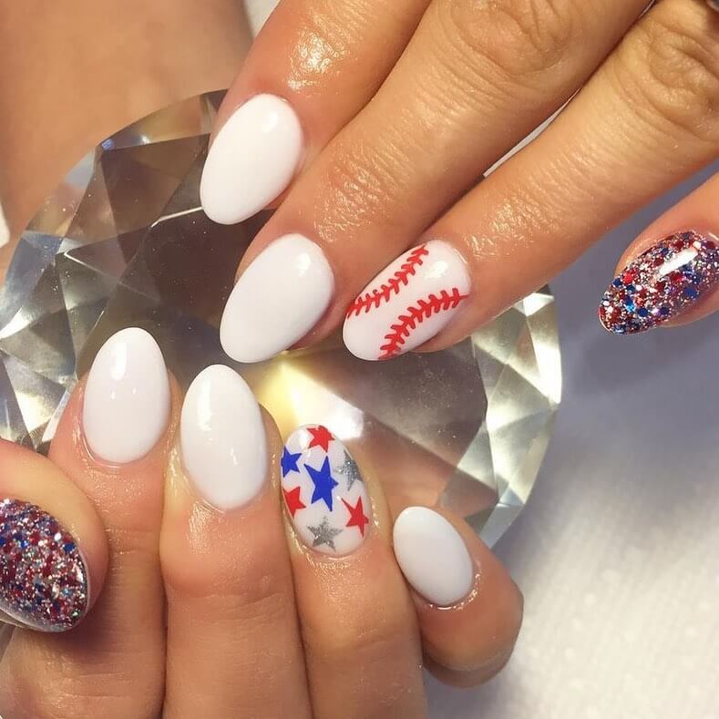 Colorful 4th of July nails featuring stars, stripes, and glitter in red, white, and blue.