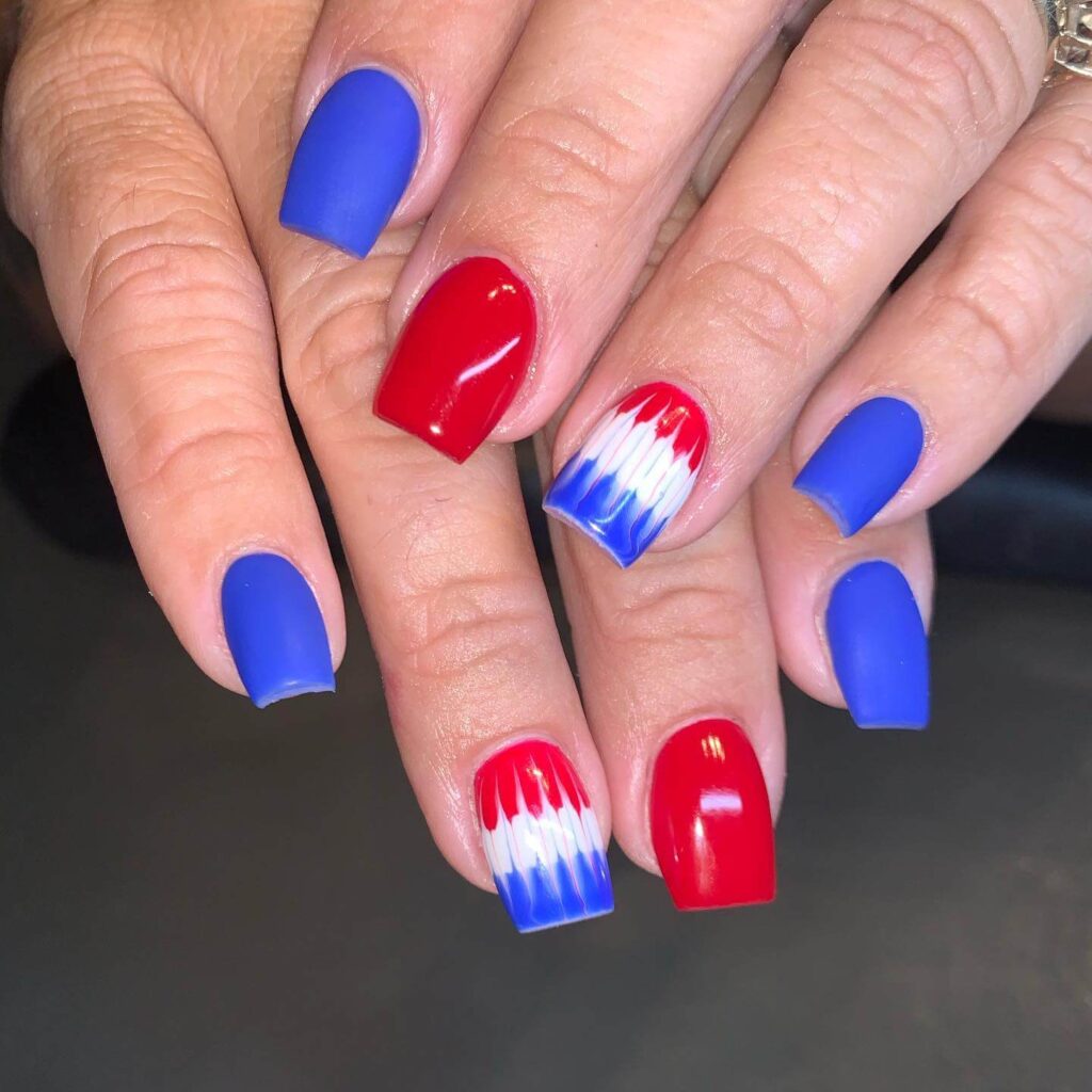 Colorful 4th of July nails featuring stars, stripes, and glitter in red, white, and blue.