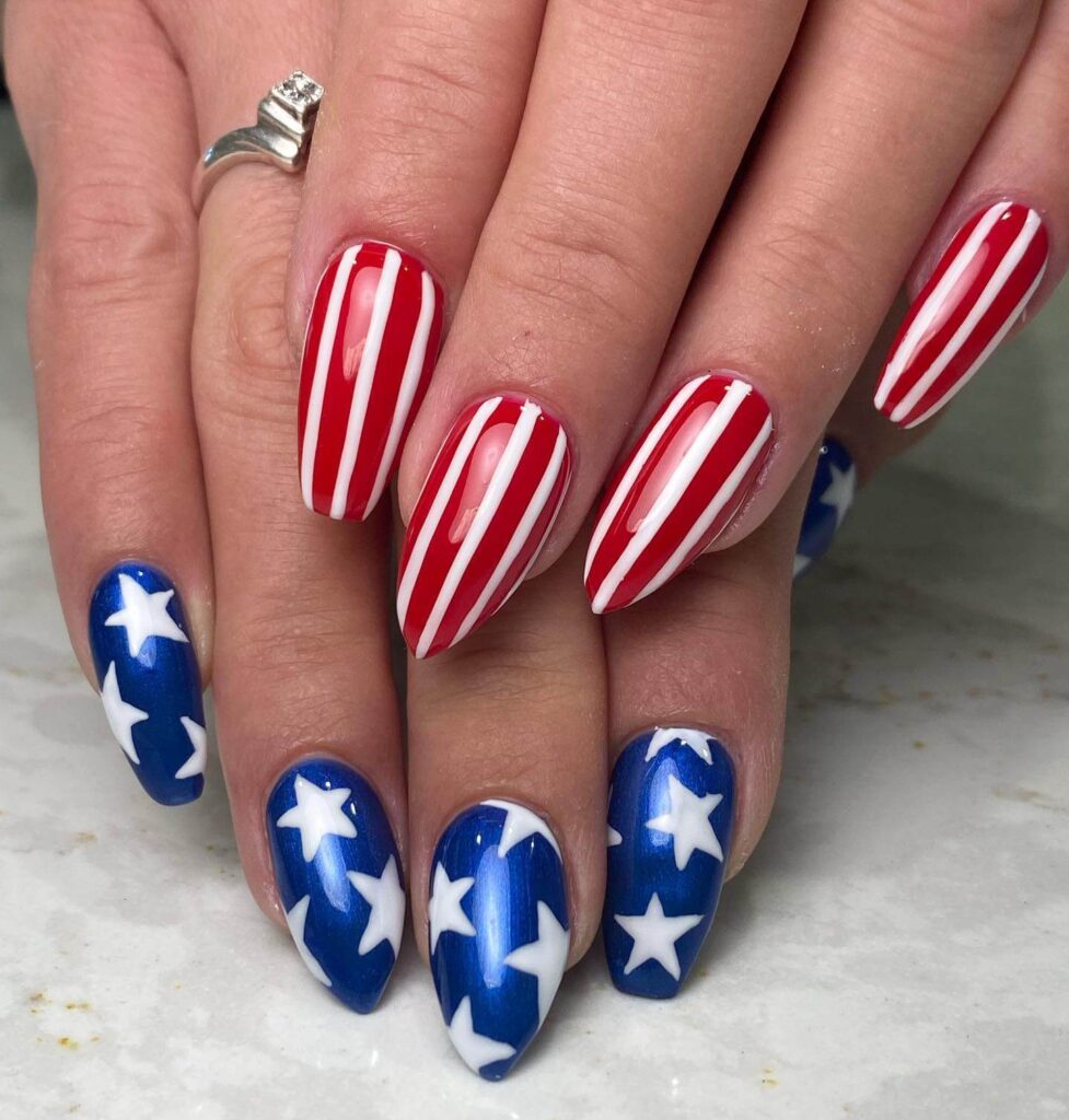 Colorful 4th of July nails featuring stars, stripes, and glitter in red, white, and blue.