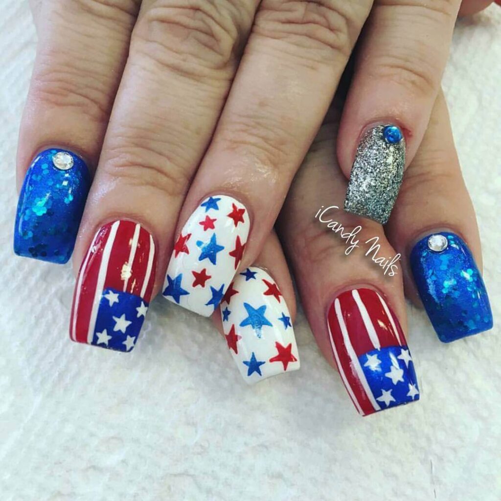 Colorful 4th of July nails featuring stars, stripes, and glitter in red, white, and blue.