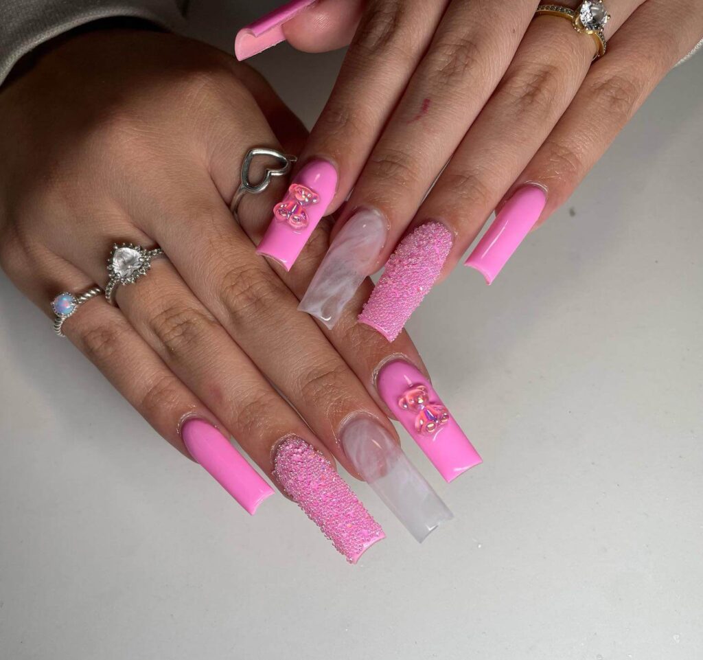 Various pink nail designs including bright pink nail designs, cute pink nail designs, and Christmas nails in pink with intricate patterns and decorations.