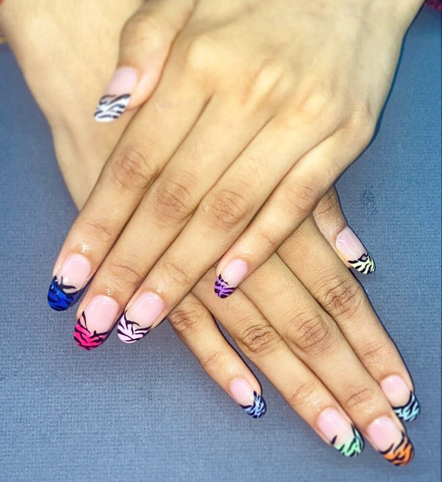 Bright and playful summer nail art with vibrant shades of blue, pink, and yellow, featuring beach-inspired designs and floral patterns.