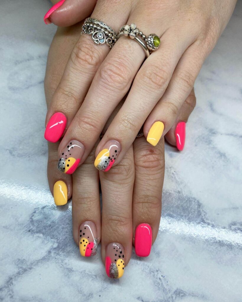 Bright and playful summer nail art with vibrant shades of blue, pink, and yellow, featuring beach-inspired designs and floral patterns.