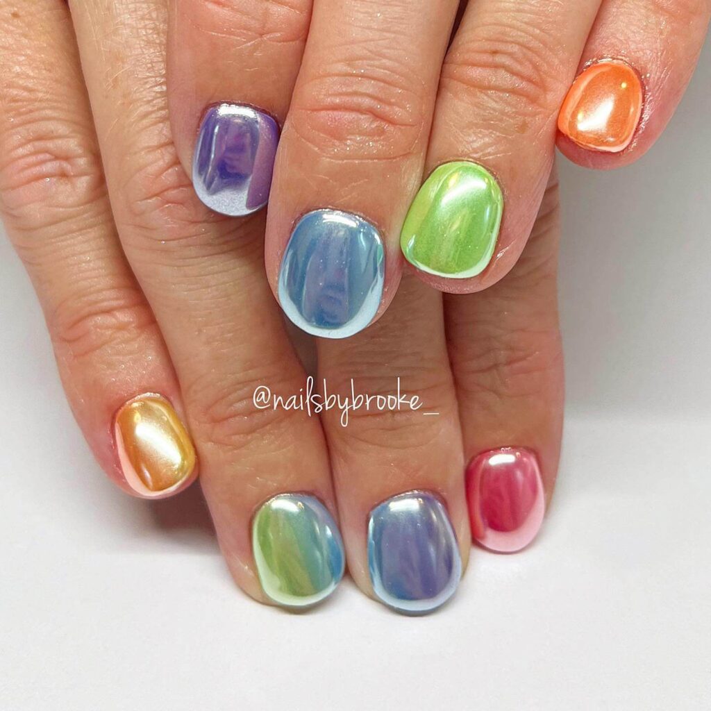 Bright and playful summer nail art with vibrant shades of blue, pink, and yellow, featuring beach-inspired designs and floral patterns.