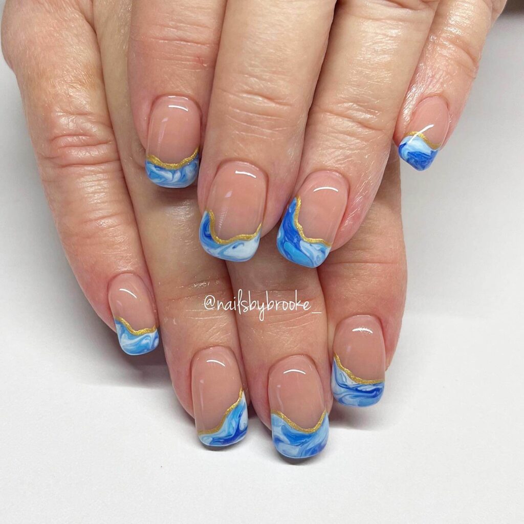 Bright and playful summer nail art with vibrant shades of blue, pink, and yellow, featuring beach-inspired designs and floral patterns.