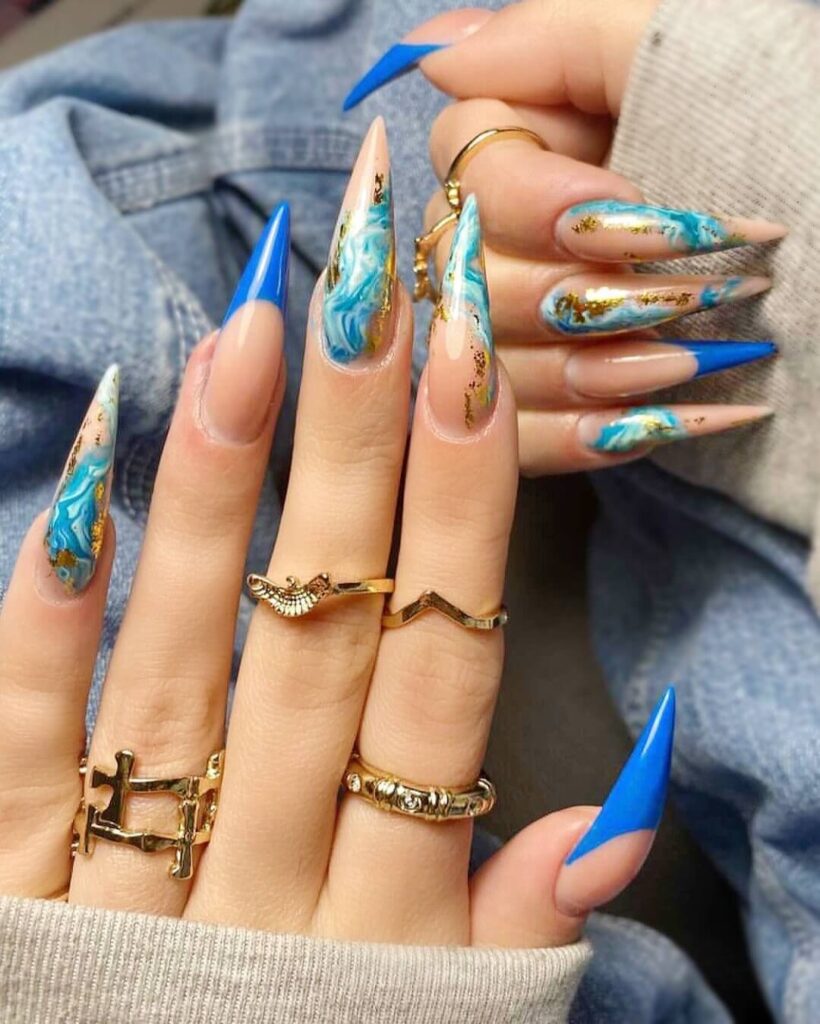 Bright and playful summer nail art with vibrant shades of blue, pink, and yellow, featuring beach-inspired designs and floral patterns.