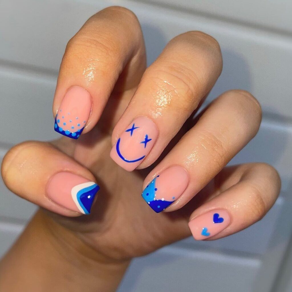 Bright and playful summer nail art with vibrant shades of blue, pink, and yellow, featuring beach-inspired designs and floral patterns.