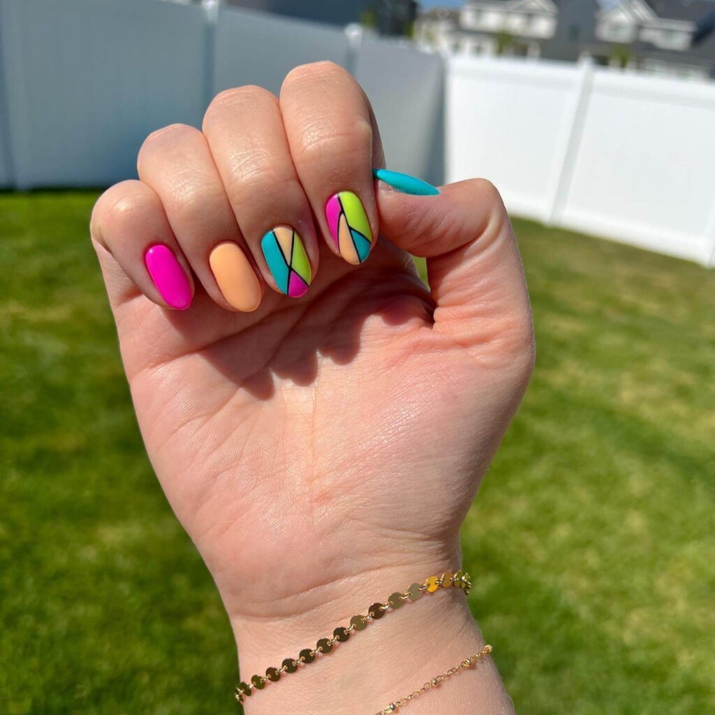 Bright and playful summer nail art with vibrant shades of blue, pink, and yellow, featuring beach-inspired designs and floral patterns.