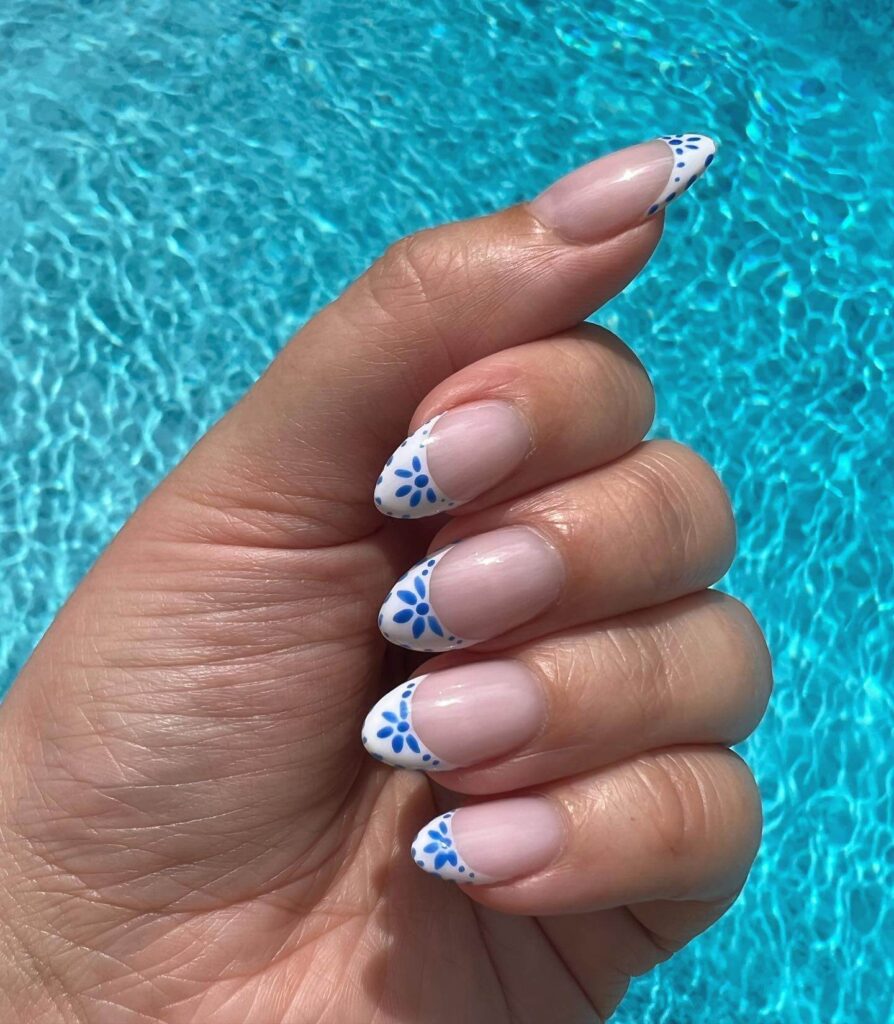 Bright and playful summer nail art with vibrant shades of blue, pink, and yellow, featuring beach-inspired designs and floral patterns.