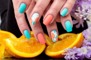 Array of summer nail designs showcasing bright colors and creative patterns on beautifully manicured nails.