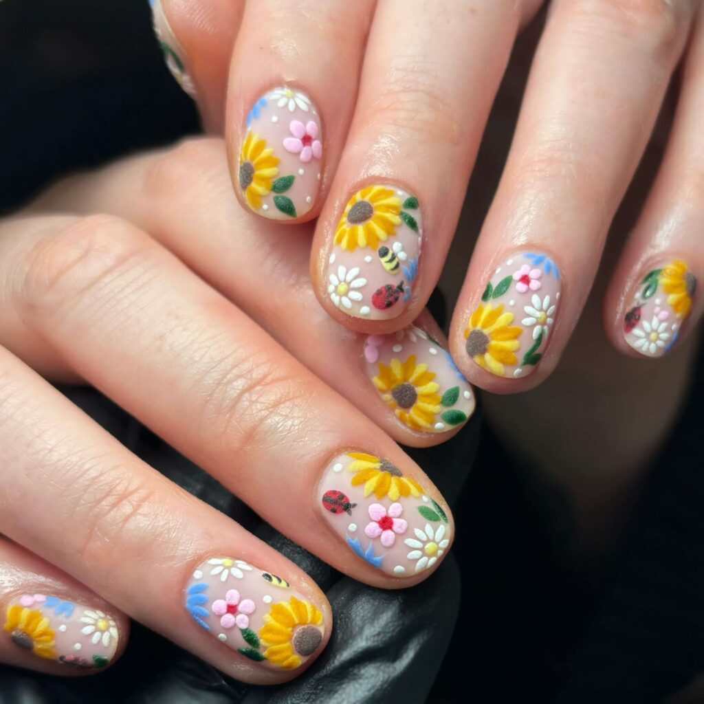 Elegant sunflower nails with intricate designs on both gel and matte finishes, perfect for any season.