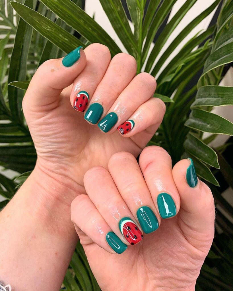 Bright watermelon nails featuring vibrant summer pink and green polish, accented with playful black seeds, perfect for a fresh summer look.