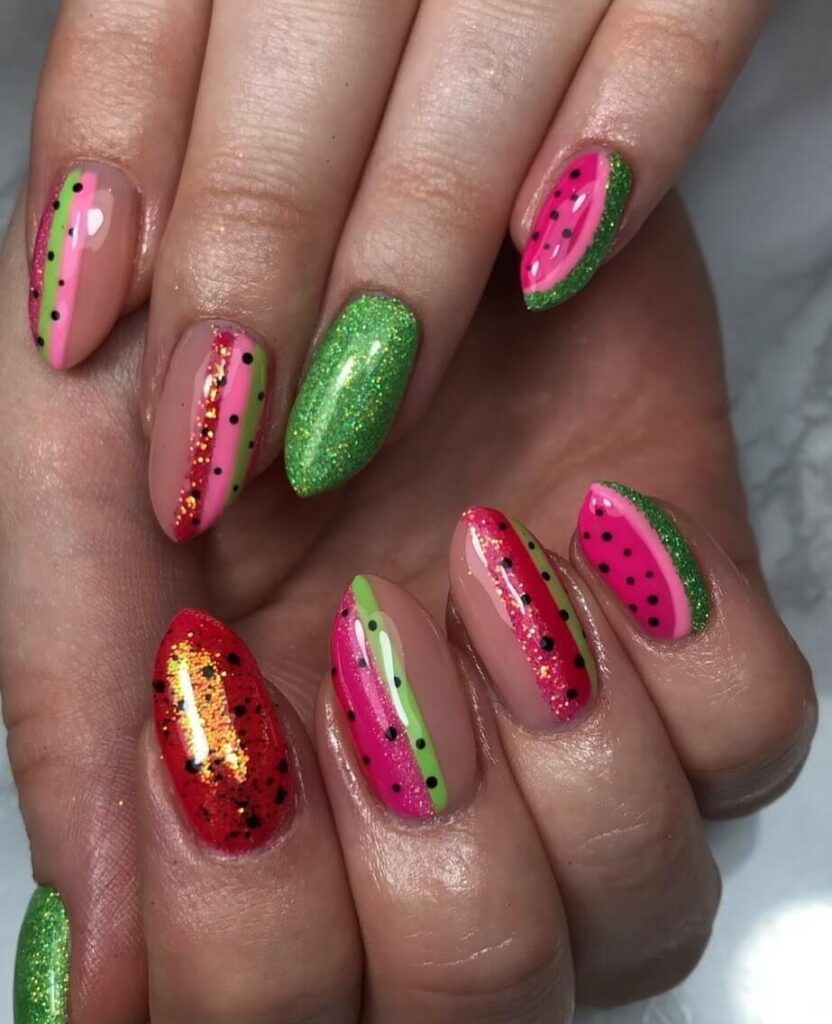 Bright watermelon nails featuring vibrant summer pink and green polish, accented with playful black seeds, perfect for a fresh summer look.
