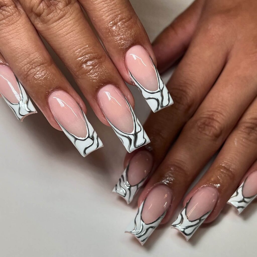 Close-up of hands showcasing various metallic nails designs, including black nails with silver flakes, dark gold nail polish, and metallic red acrylic nails.