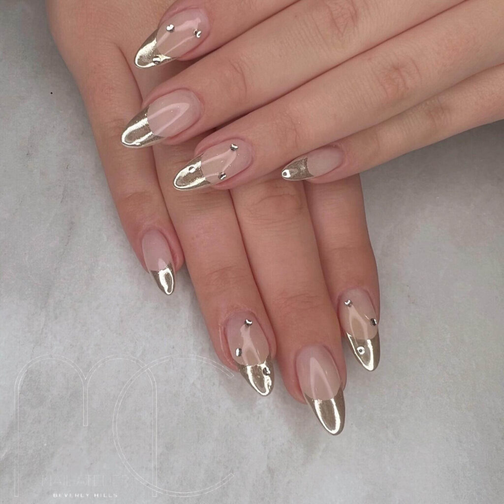 Close-up of hands showcasing various metallic nails designs, including black nails with silver flakes, dark gold nail polish, and metallic red acrylic nails.