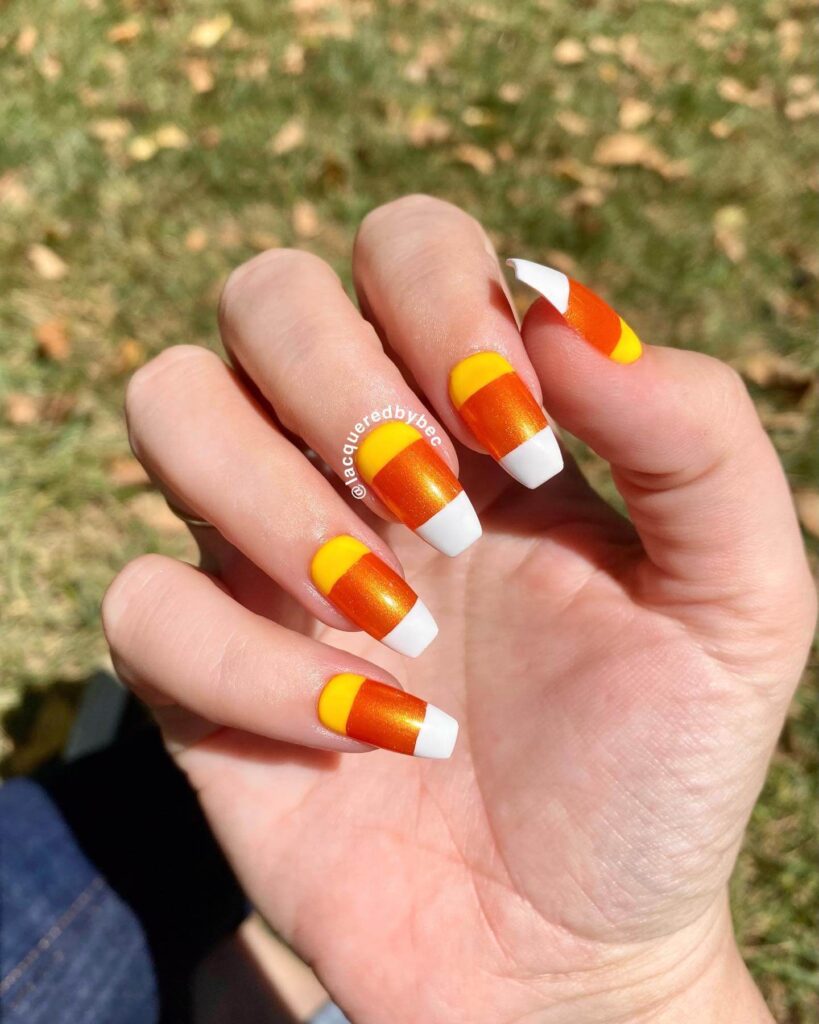 Festive candy corn nails with vibrant Halloween colors and cute designs like pumpkins and scarecrows.