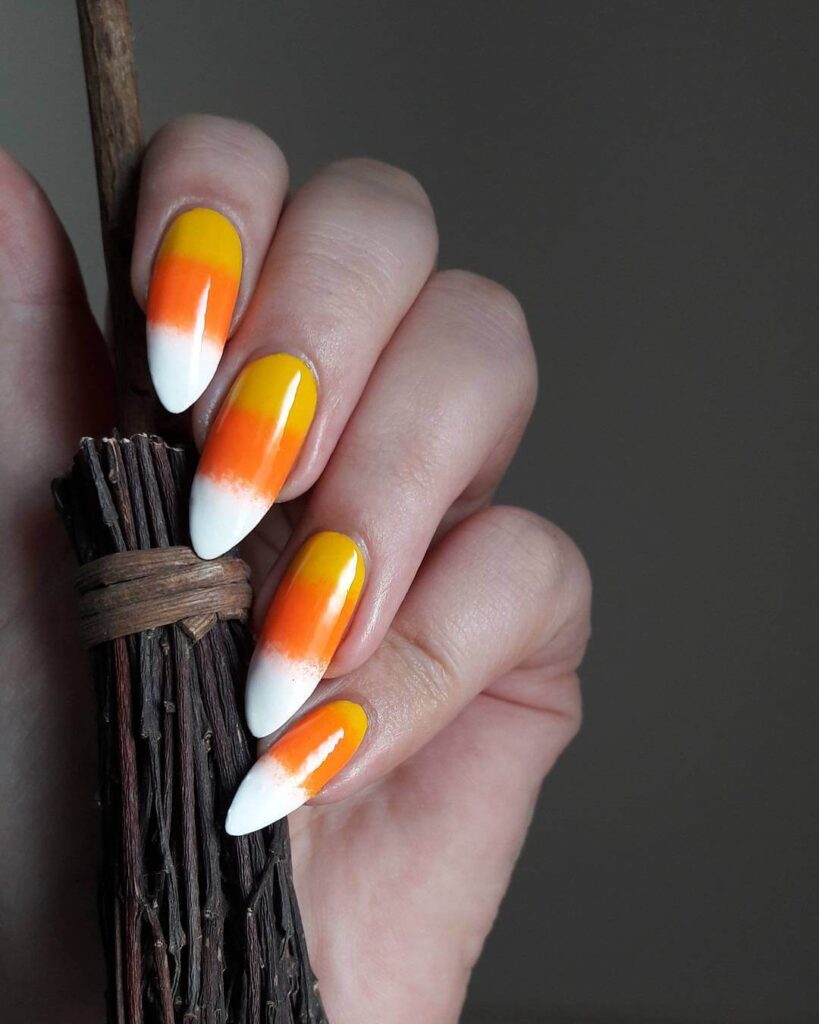 Festive candy corn nails with vibrant Halloween colors and cute designs like pumpkins and scarecrows.