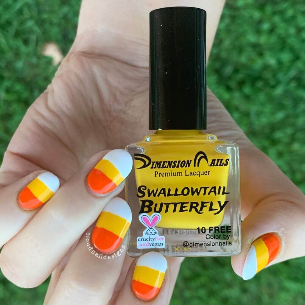 Festive candy corn nails with vibrant Halloween colors and cute designs like pumpkins and scarecrows.