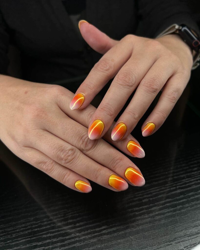 Festive candy corn nails with vibrant Halloween colors and cute designs like pumpkins and scarecrows.