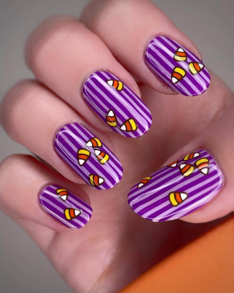 Festive candy corn nails with vibrant Halloween colors and cute designs like pumpkins and scarecrows.