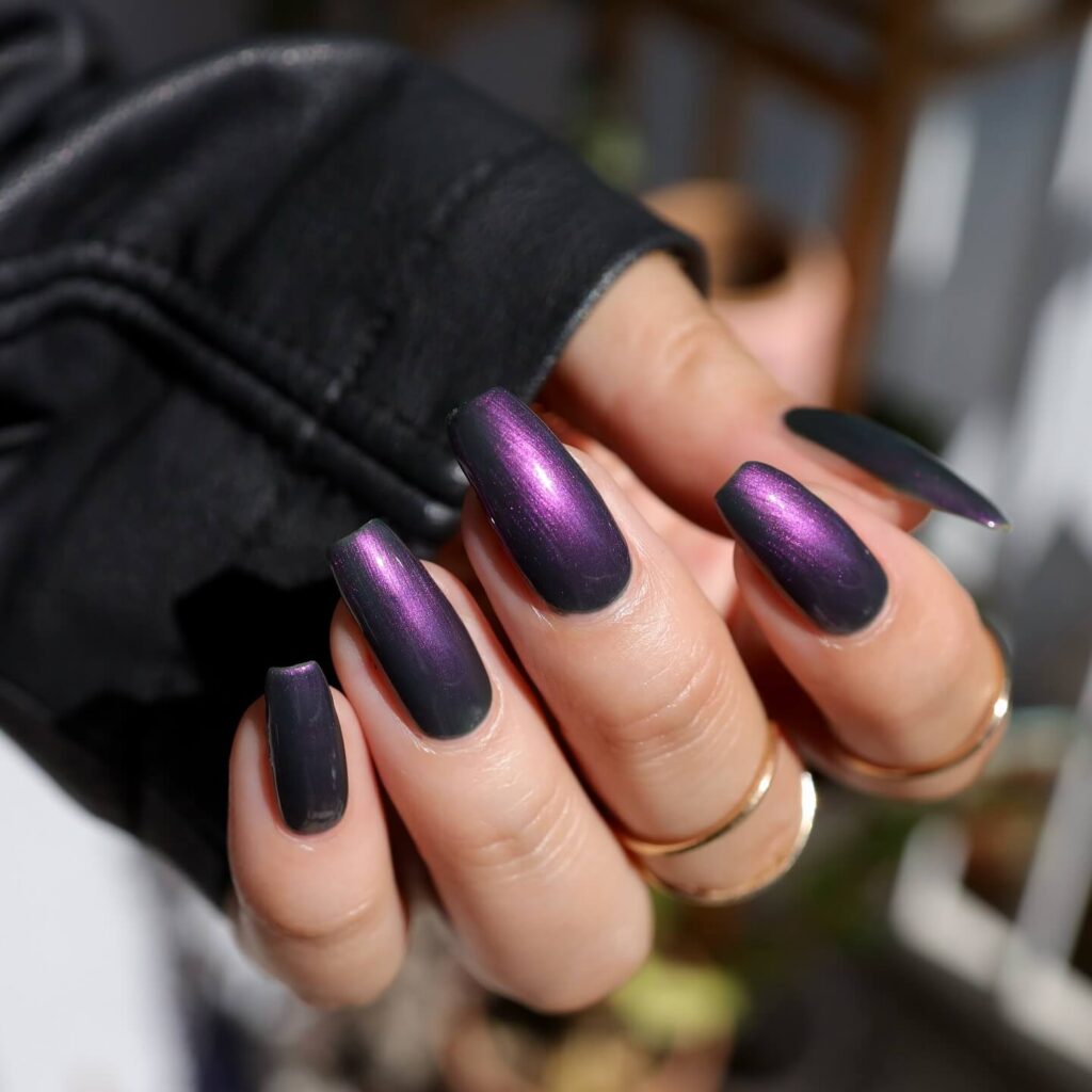 A close-up of elegant dark purple nails with matte purple and ombre nail designs, perfect for both everyday wear and Halloween.