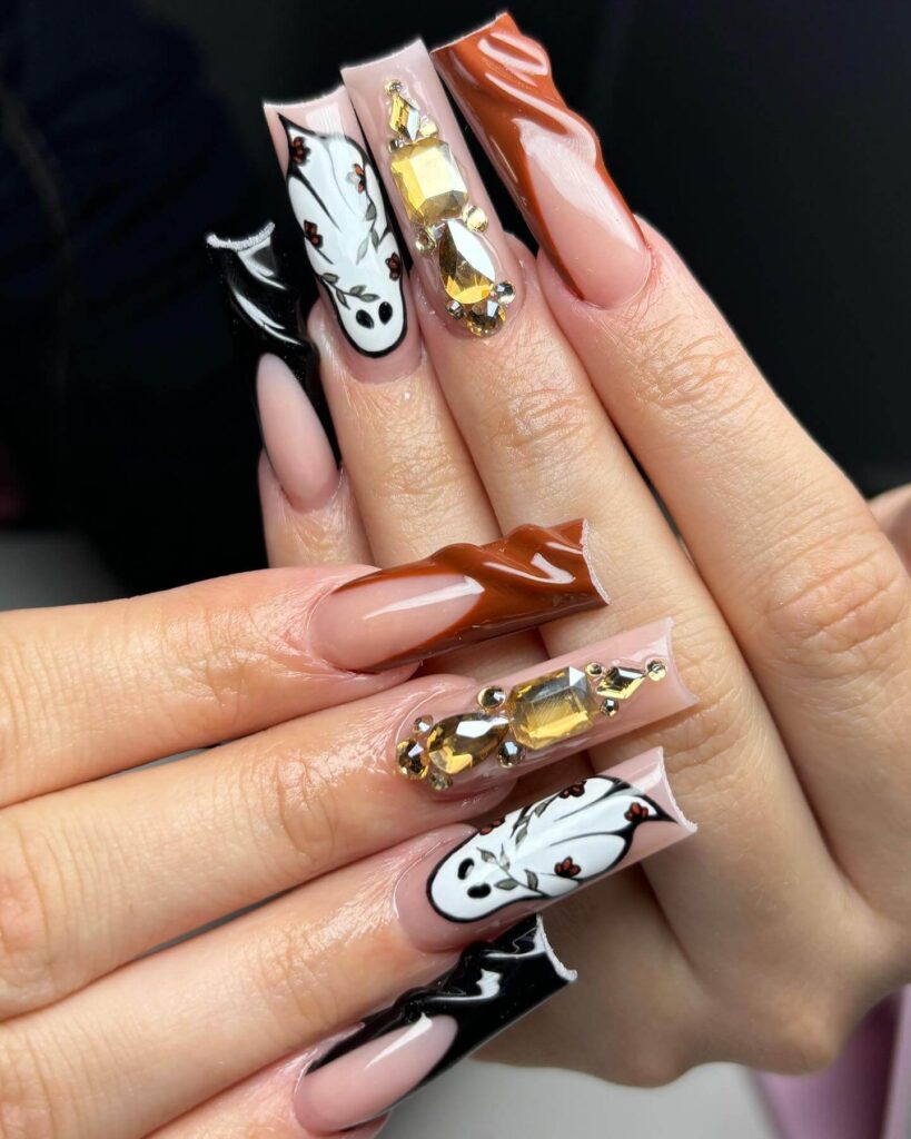 A set of Halloween acrylic nails with spooky nail designs, including black and red accents, ghosts, and candy corn-themed nails.