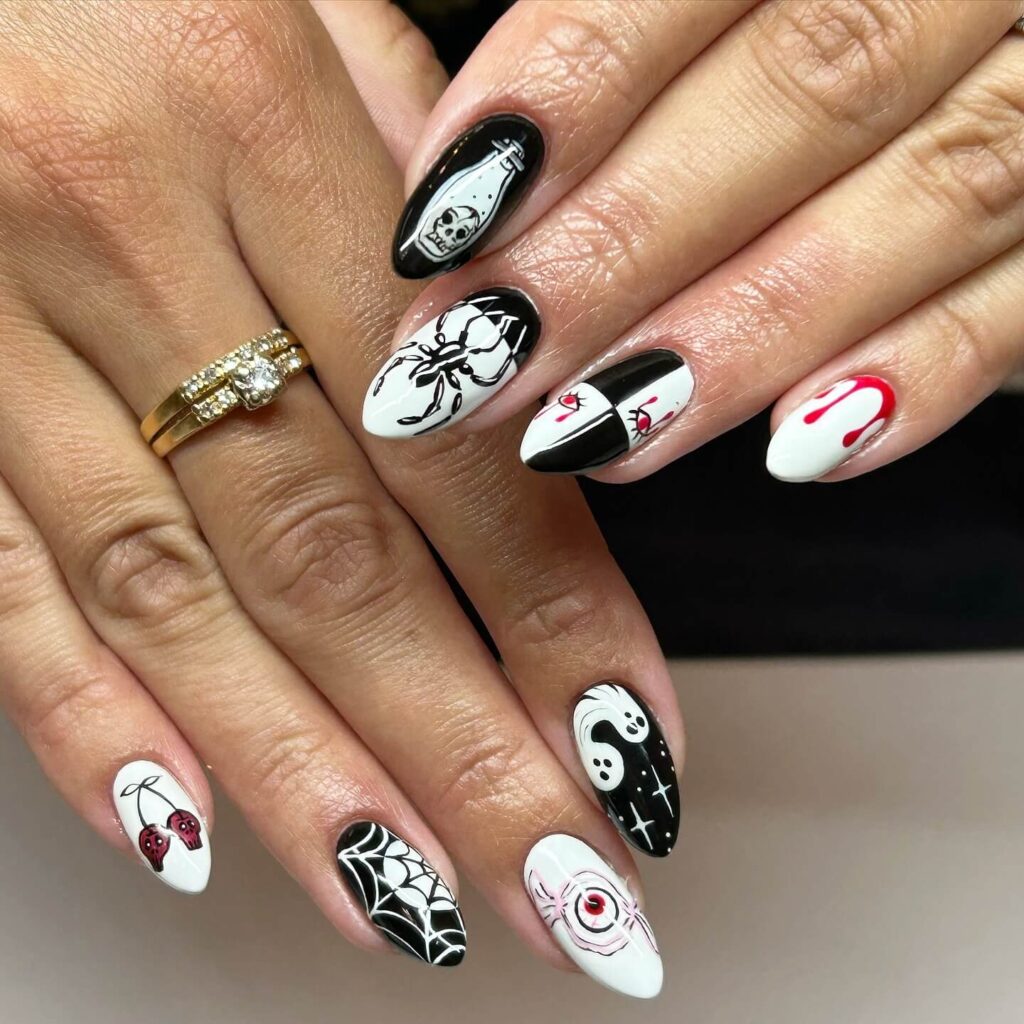 A set of Halloween acrylic nails with spooky nail designs, including black and red accents, ghosts, and candy corn-themed nails.