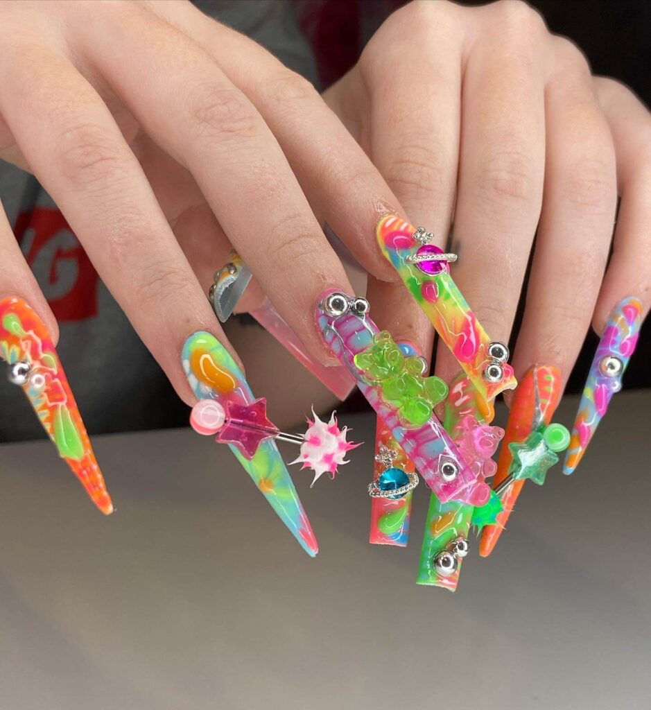 A set of Halloween acrylic nails with spooky nail designs, including black and red accents, ghosts, and candy corn-themed nails.