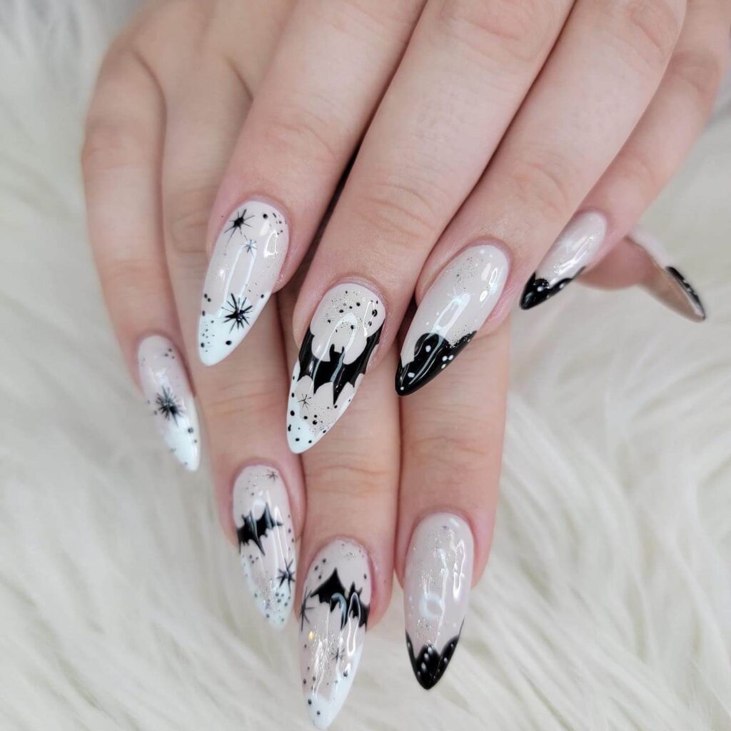 A set of Halloween acrylic nails with spooky nail designs, including black and red accents, ghosts, and candy corn-themed nails.