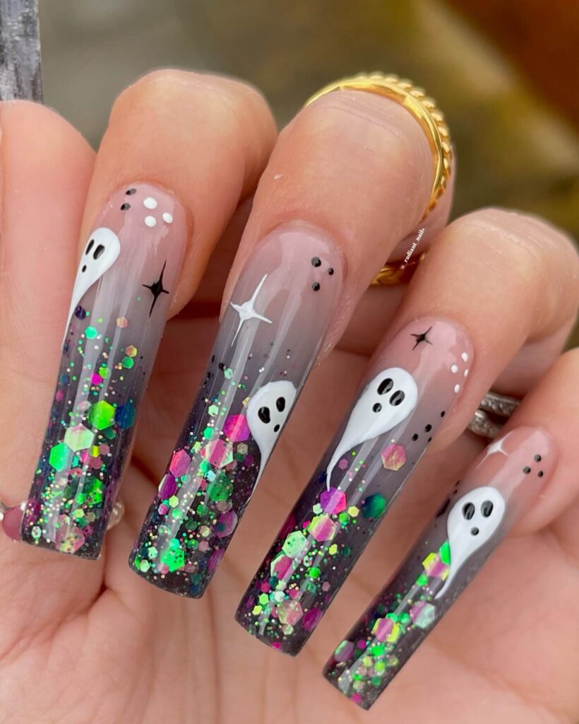 A set of Halloween acrylic nails with spooky nail designs, including black and red accents, ghosts, and candy corn-themed nails.