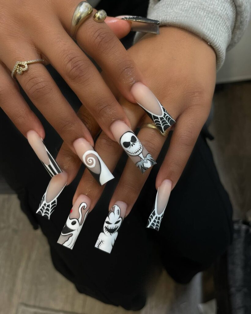 A set of Halloween acrylic nails with spooky nail designs, including black and red accents, ghosts, and candy corn-themed nails.