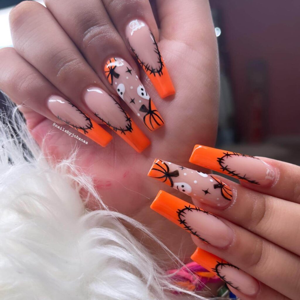 A set of Halloween acrylic nails with spooky nail designs, including black and red accents, ghosts, and candy corn-themed nails.