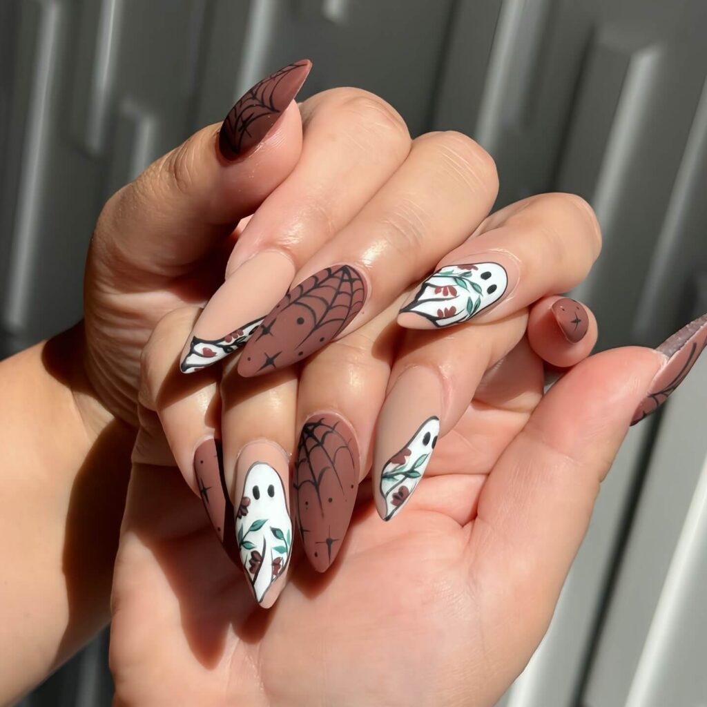 A variety of Halloween nail art designs, featuring ghost nails, pumpkin nails, and spider web nails with a spooky, festive look.